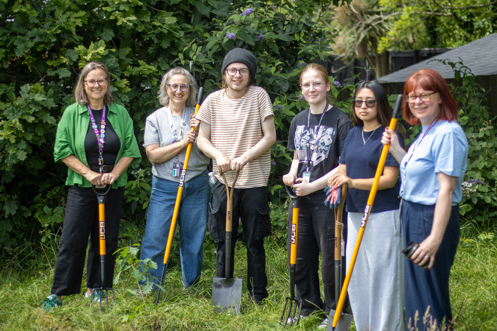 Students and staff posing with shovels