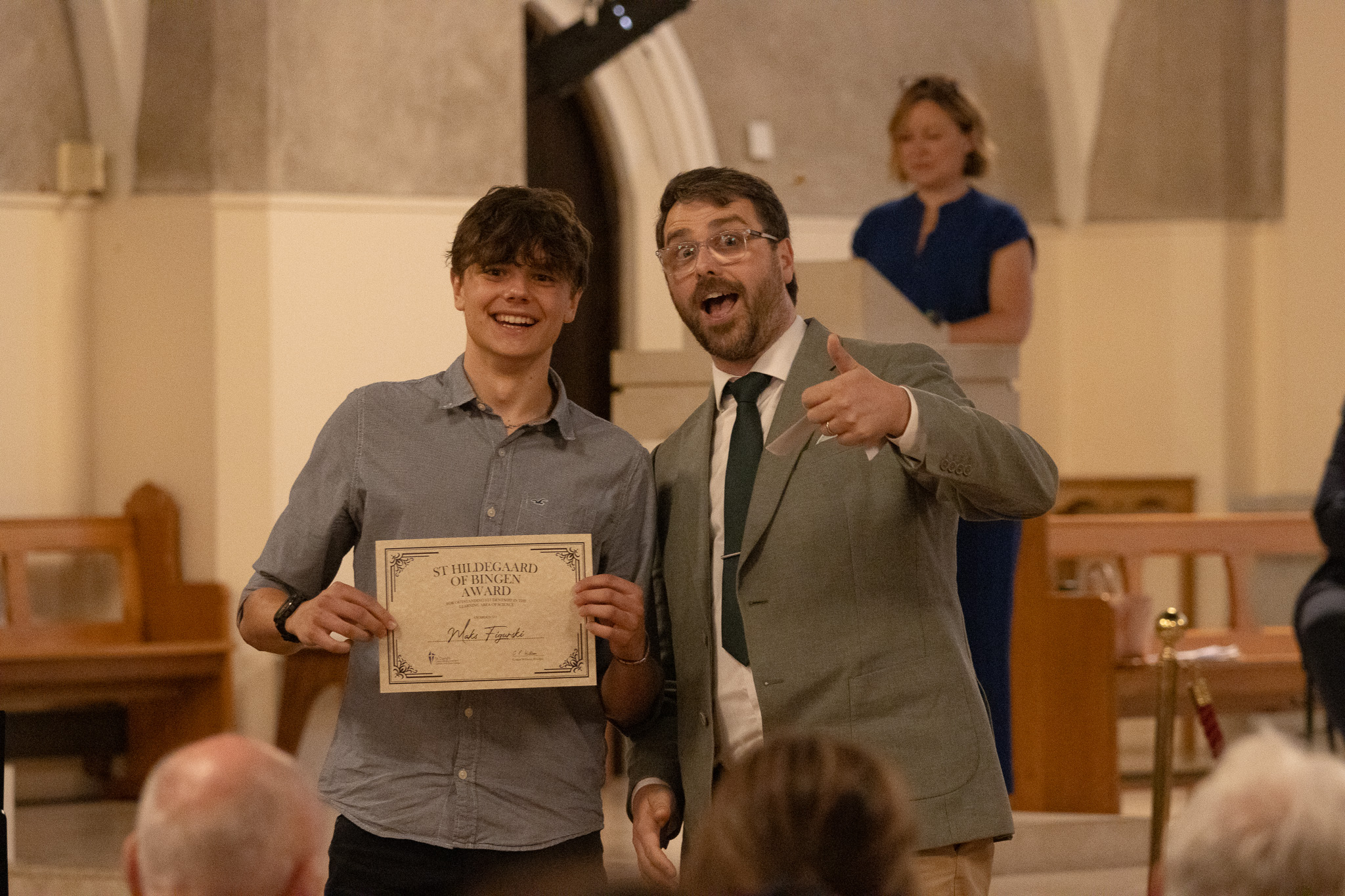 St David's staff and student looking at camera with certificate in hand.